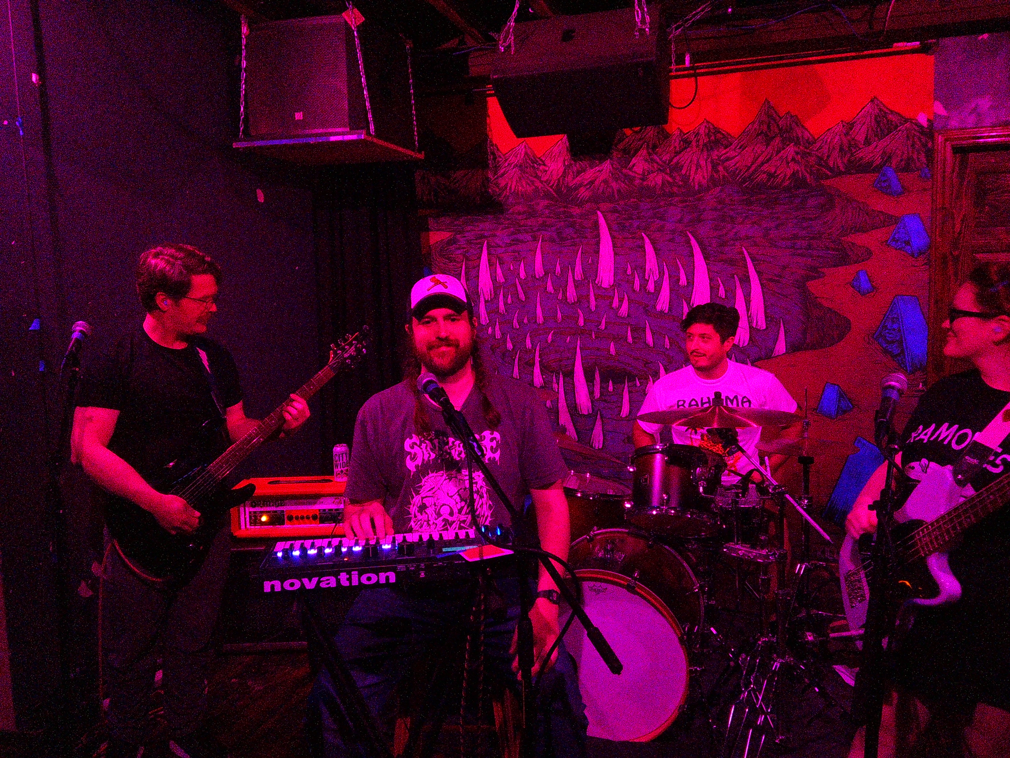 Ray centered in the image playing keys with David on his left and Adam and Haley on his right